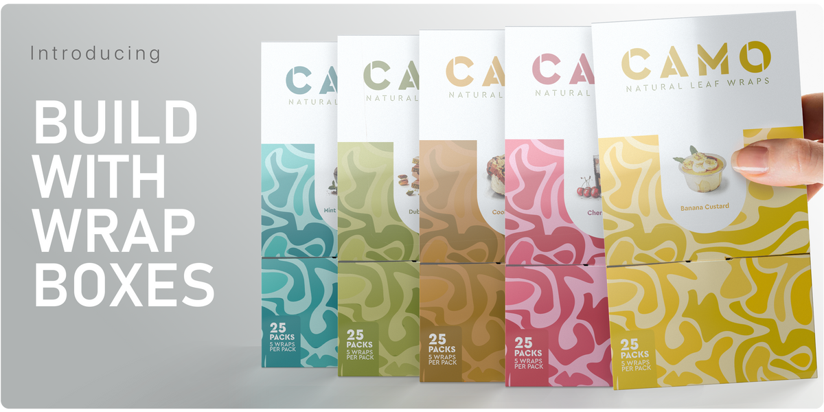Five CAMO Natural Leaf Wraps boxes in different colors and flavors are lined up. A hand holds the Banana Custard flavor box.